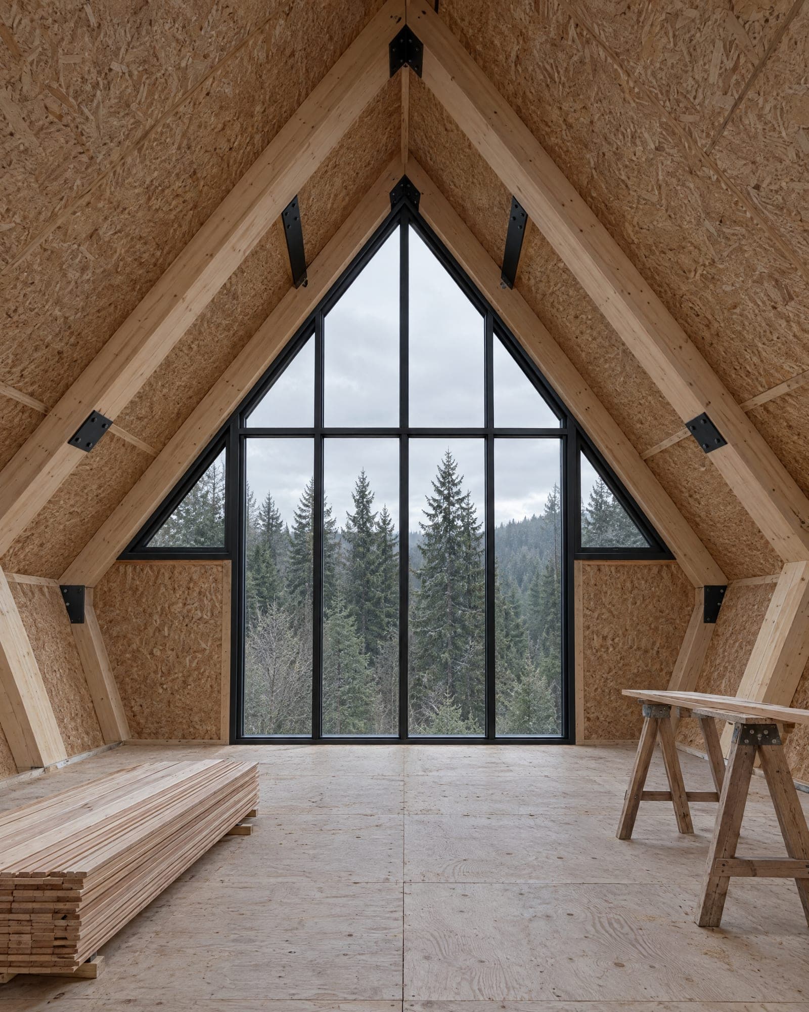 Inside a weather-tight AFRME shell: exposed frames with AFRME structural connectors, roof cassettes on, window modules installed and lining boards stacked